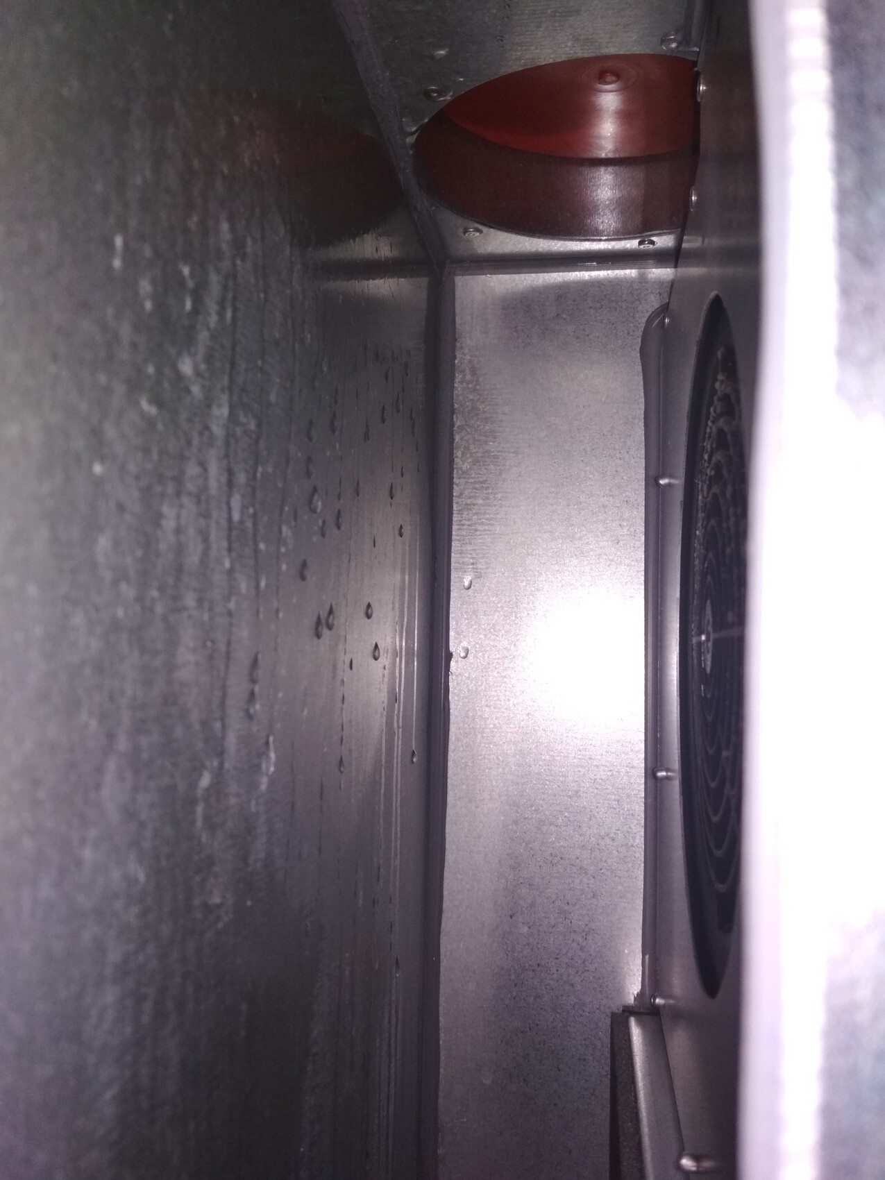 Inside view of a metallic ventilation system inside a shaft with a fan
