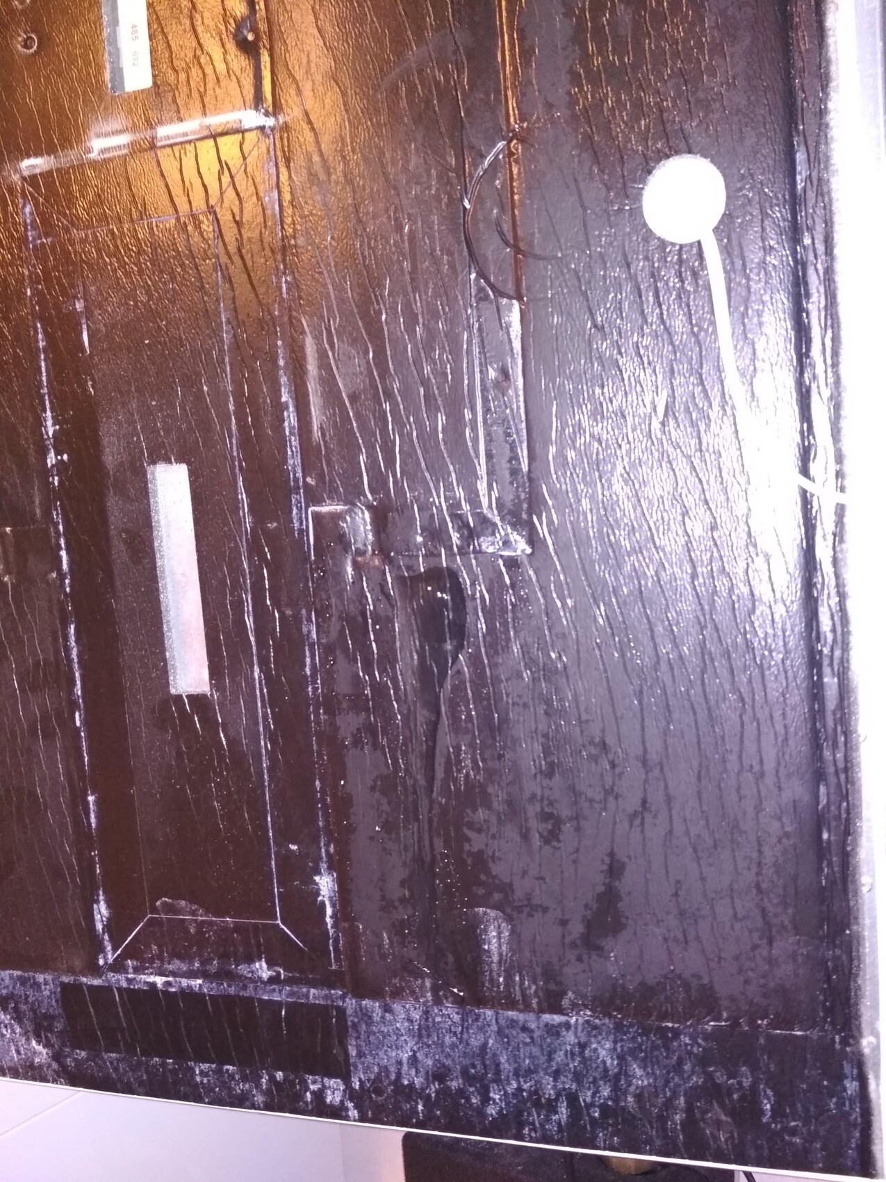 Black-painted wooden door with scratches and small details on the surface in construction condition