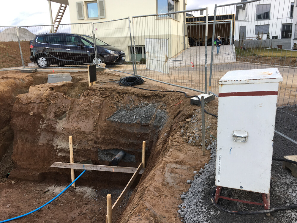 Open excavation with foundation work, construction fence and cables at site