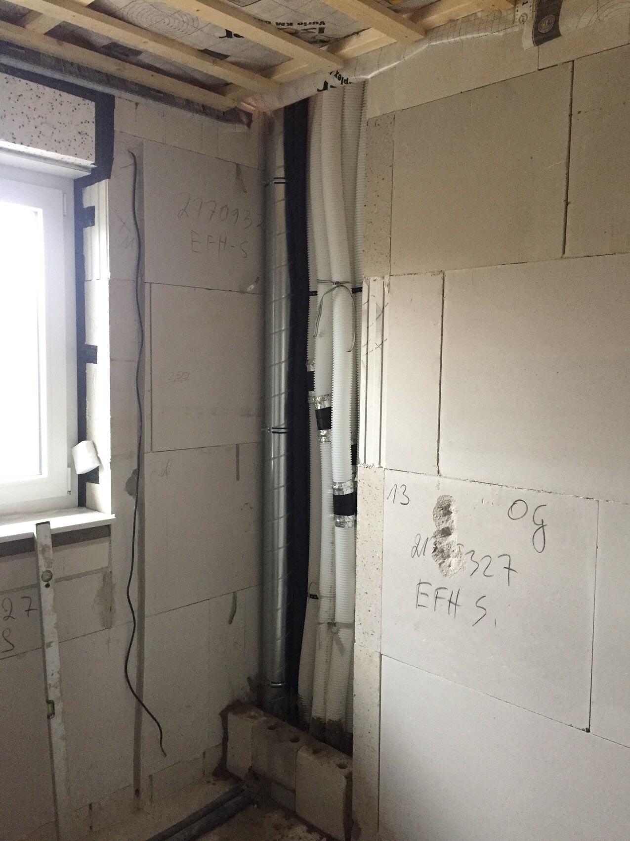 Shell interior with installation ducts, flexible conduits, and window on the left.