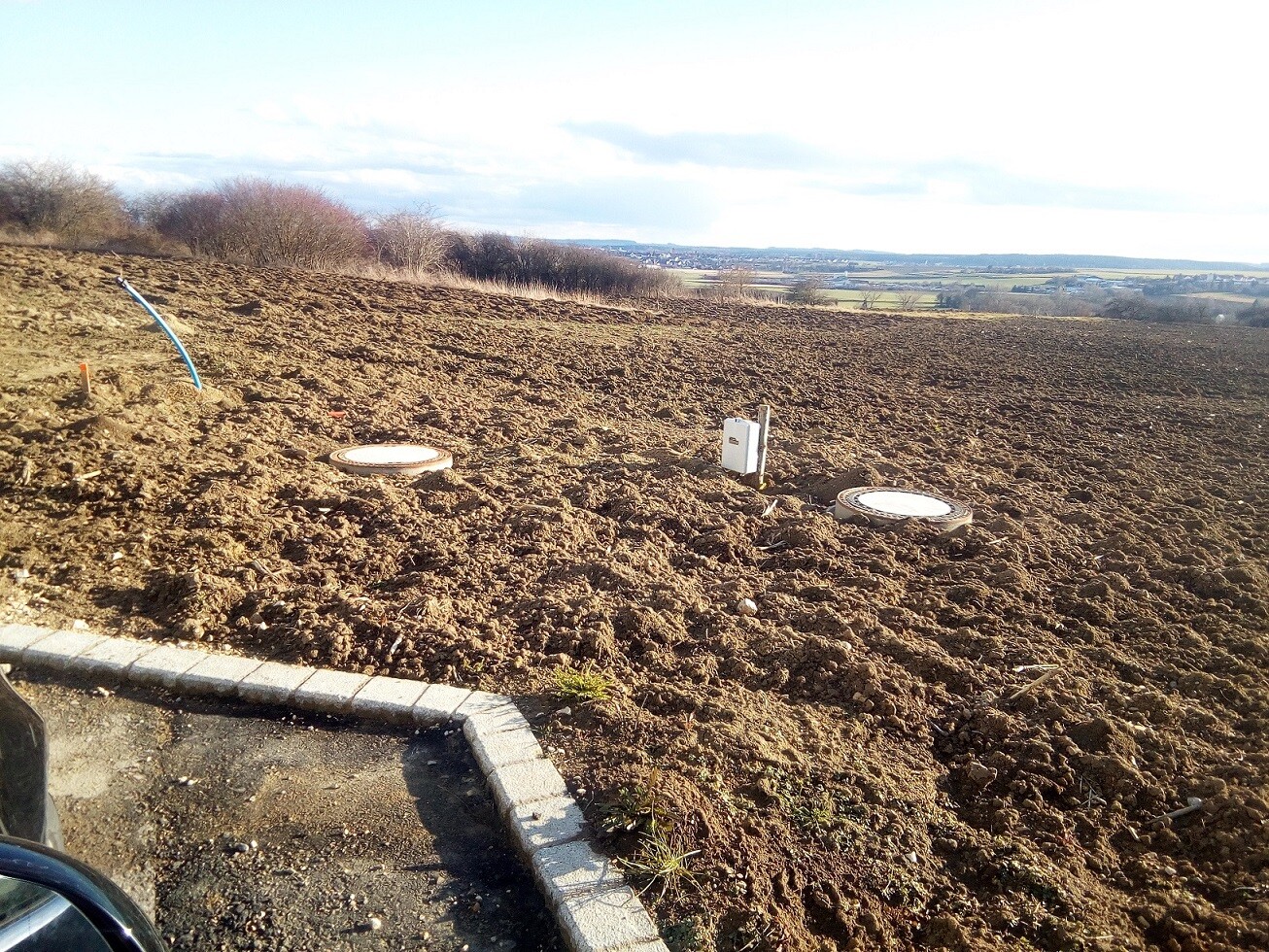 Construction site with earthworks, shell foundation, and installations on open land