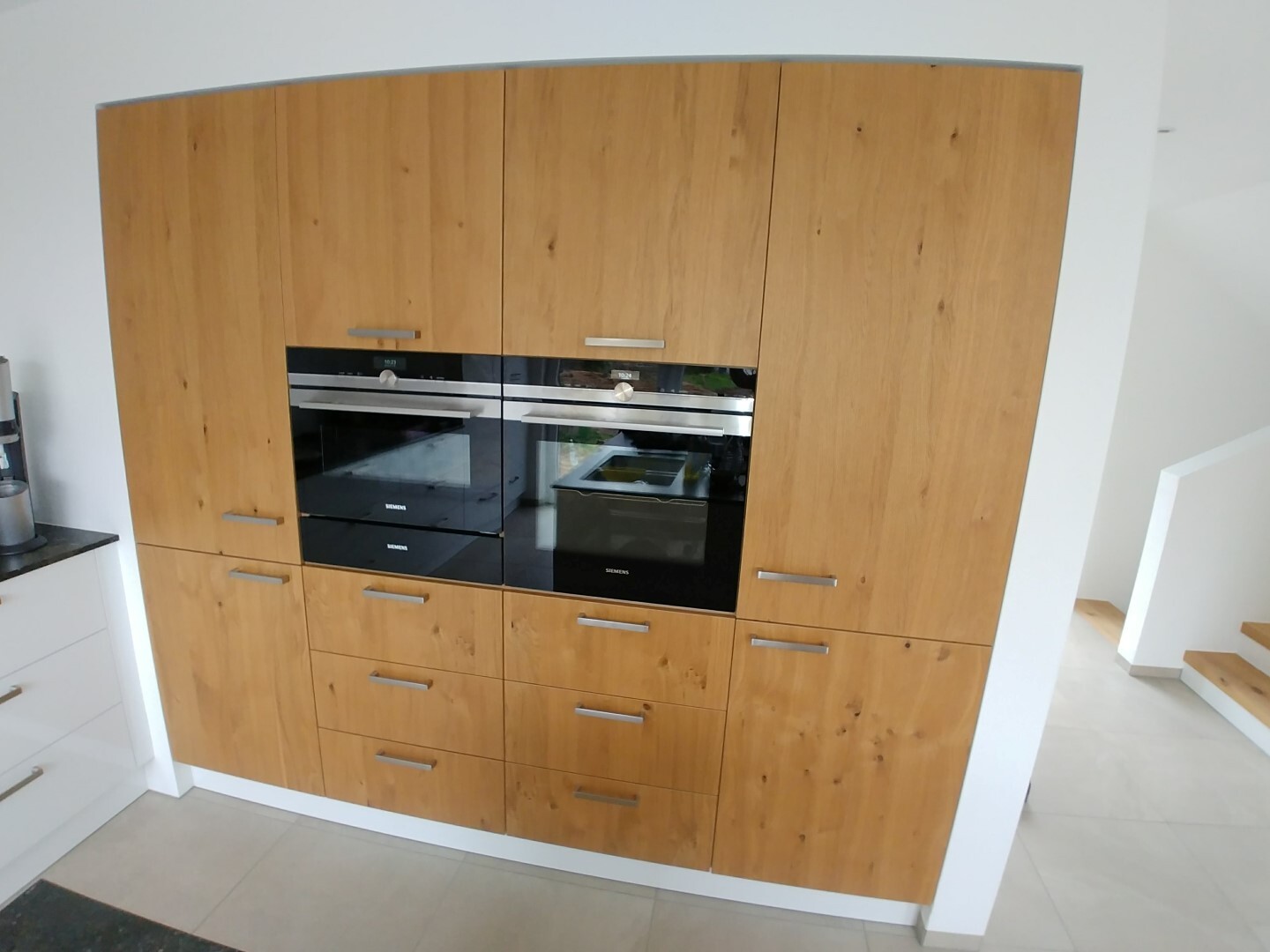 Kitchen with wood fronts and integrated Siemens ovens in a modern kitchen run