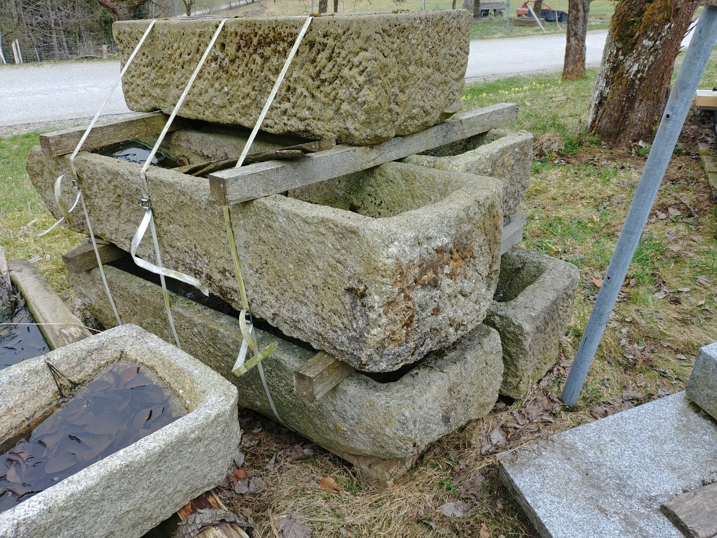 Rough stone blocks stacked as building material outdoors, secured with straps.