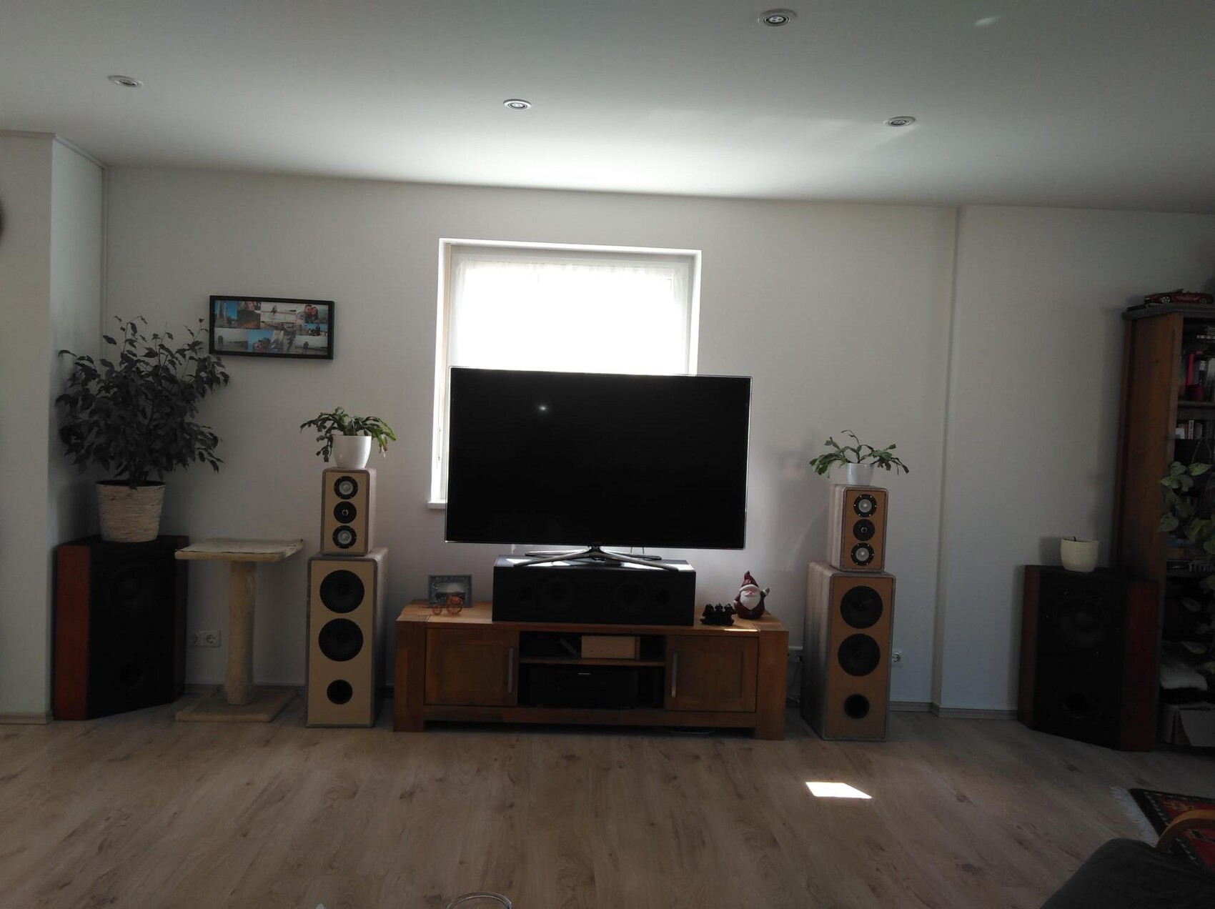 Living room with flat screen TV, floor-standing speakers and plants