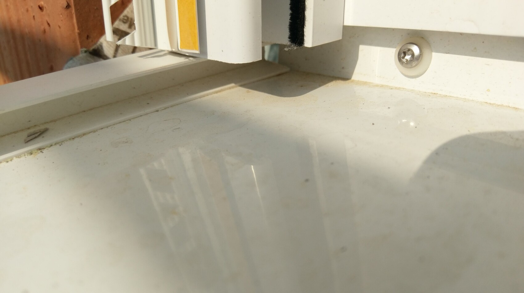 Close-up of a dirty window frame with window sill in sunlight