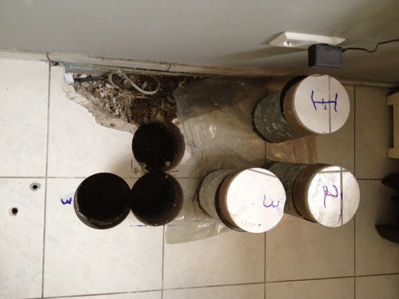 Open bathroom installation with pipes and components on tiled floor