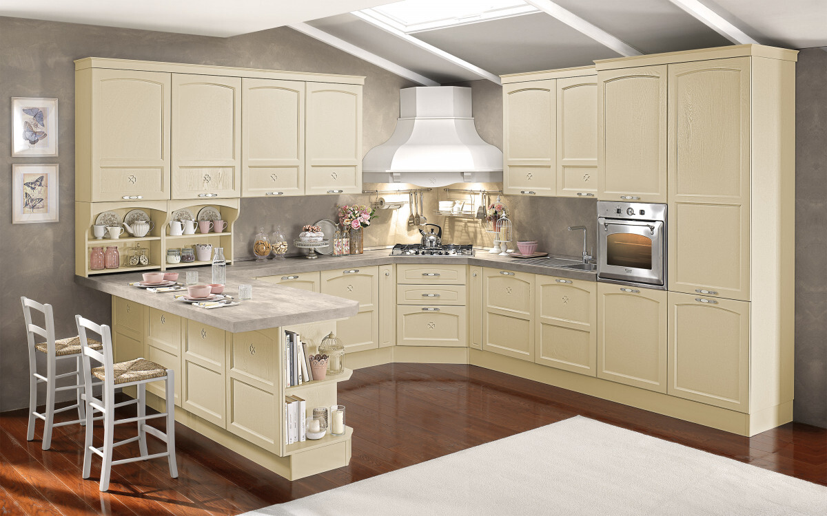 Bright kitchen with island, cream-colored cabinets, oven and extractor hood