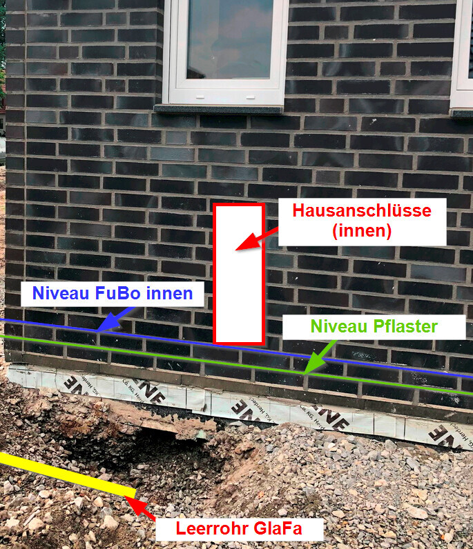 Exterior wall made of dark bricks with window; red outline of indoor house connections, yellow pipe.