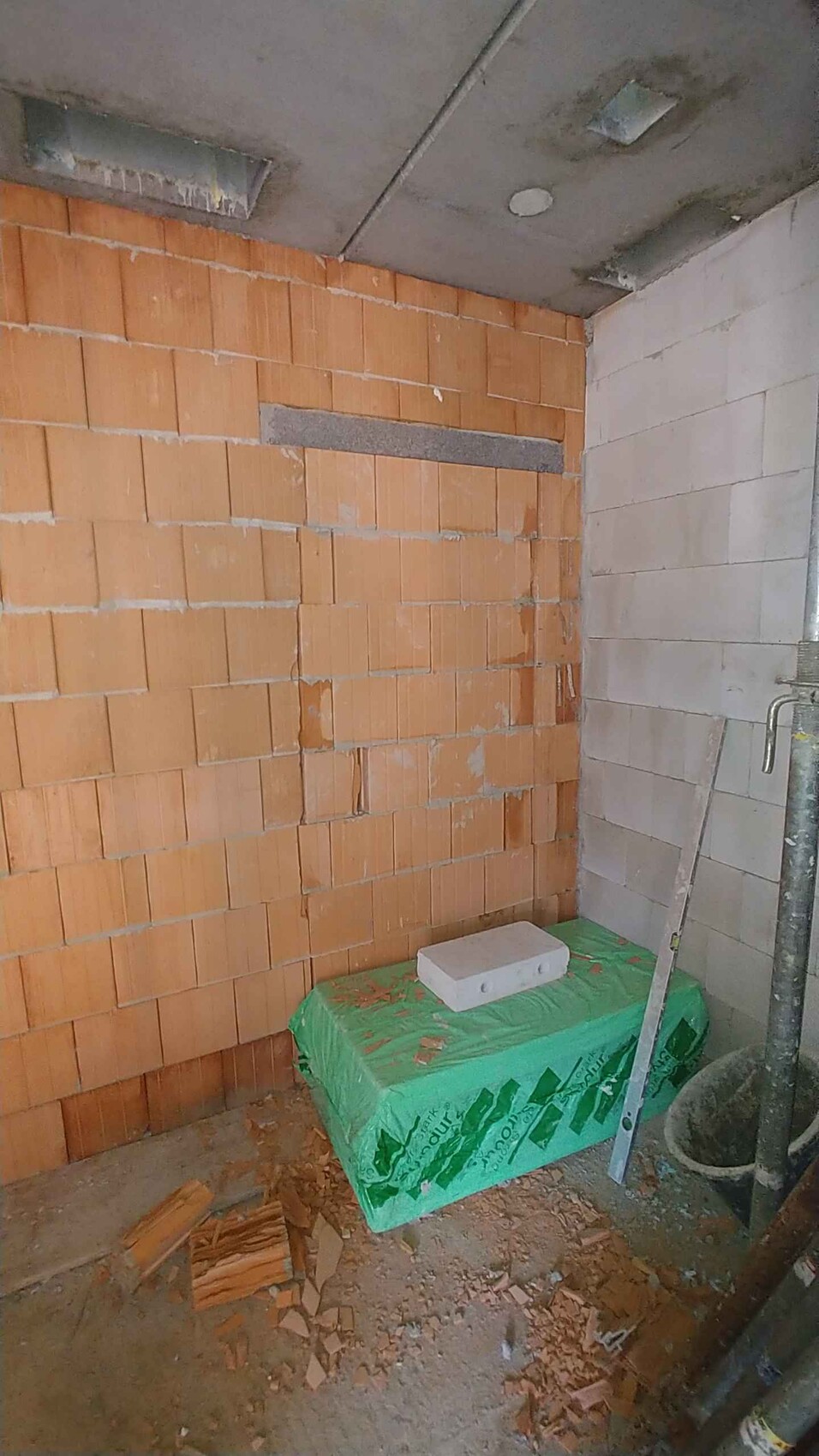 Shell: left brick wall, right concrete wall, green foil with Styrodur block, construction dust.