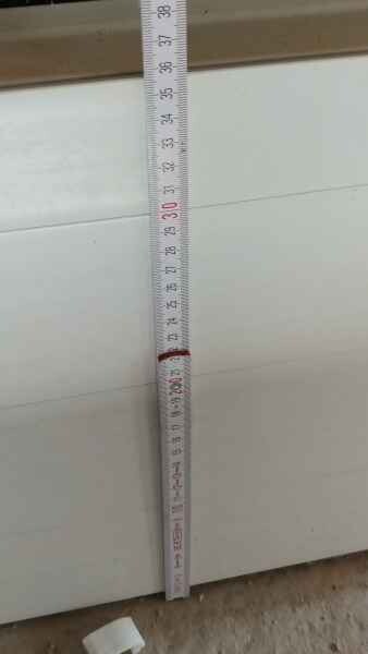 Measuring tape held vertically against a wall during interior construction work