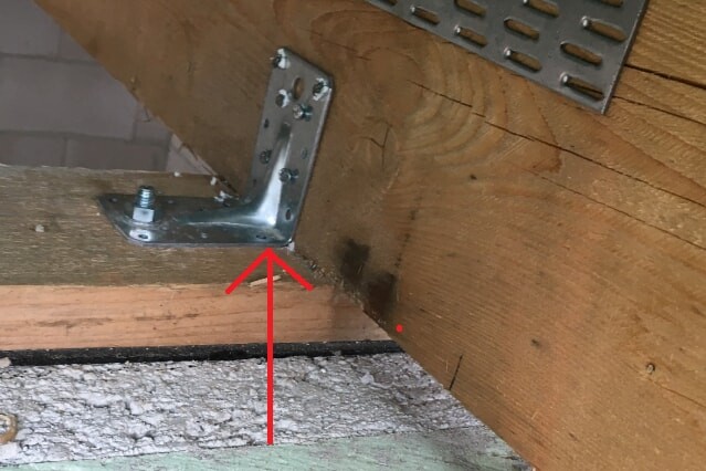 Close-up of a wooden beam with metal bracket fastening in construction