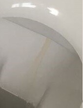 Close-up of a white bathtub edge with slight discolorations.