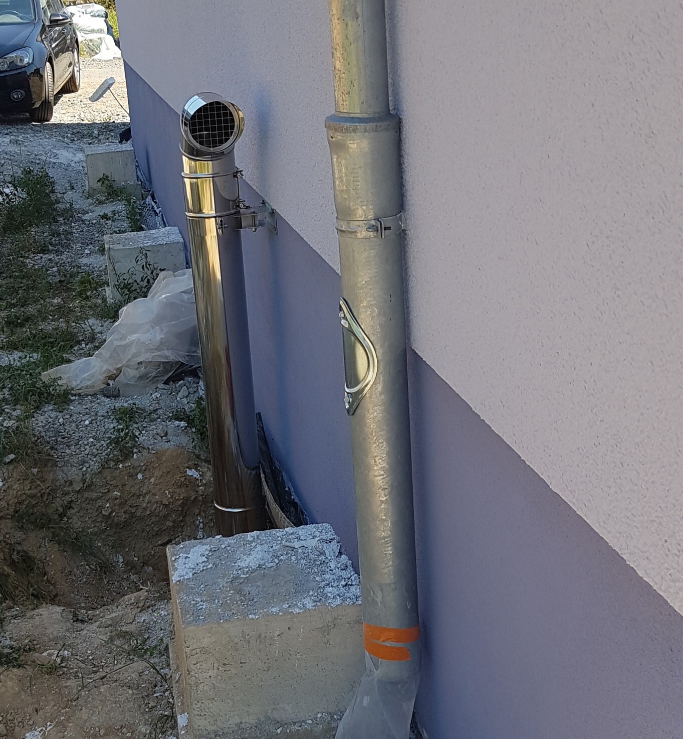 Außenwand mit Edelstahlrohren und Lüftungsrohr am Bau eines Hauses