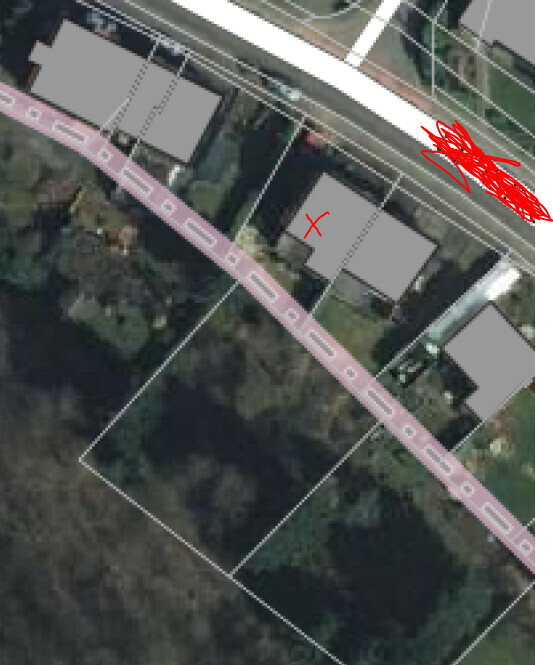 Luftaufnahme eines Baugrundstuecks mit Grundrisslinien und markiertem Standort