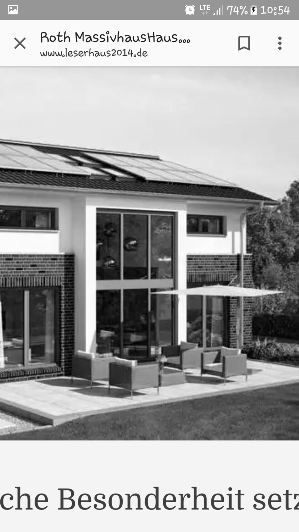 Modern family house with large glass fronts, patio furniture and parasols