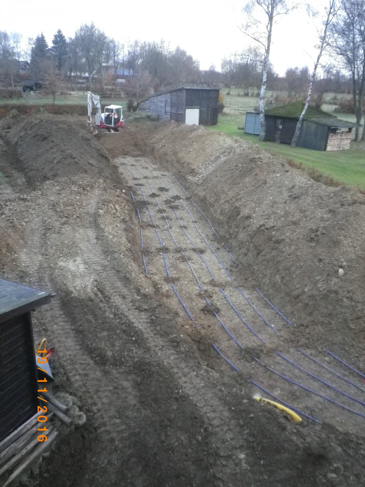Construction trench with pipes laid for underfloor heating on site