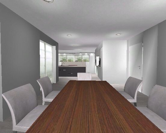 Long wooden table with gray chairs in modern dining room; open kitchen in the background.