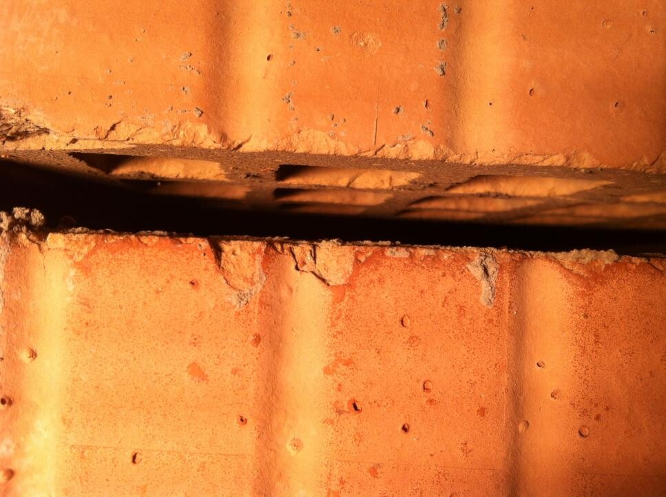 Close-up of orange roof tile with visible unevenness and gaps