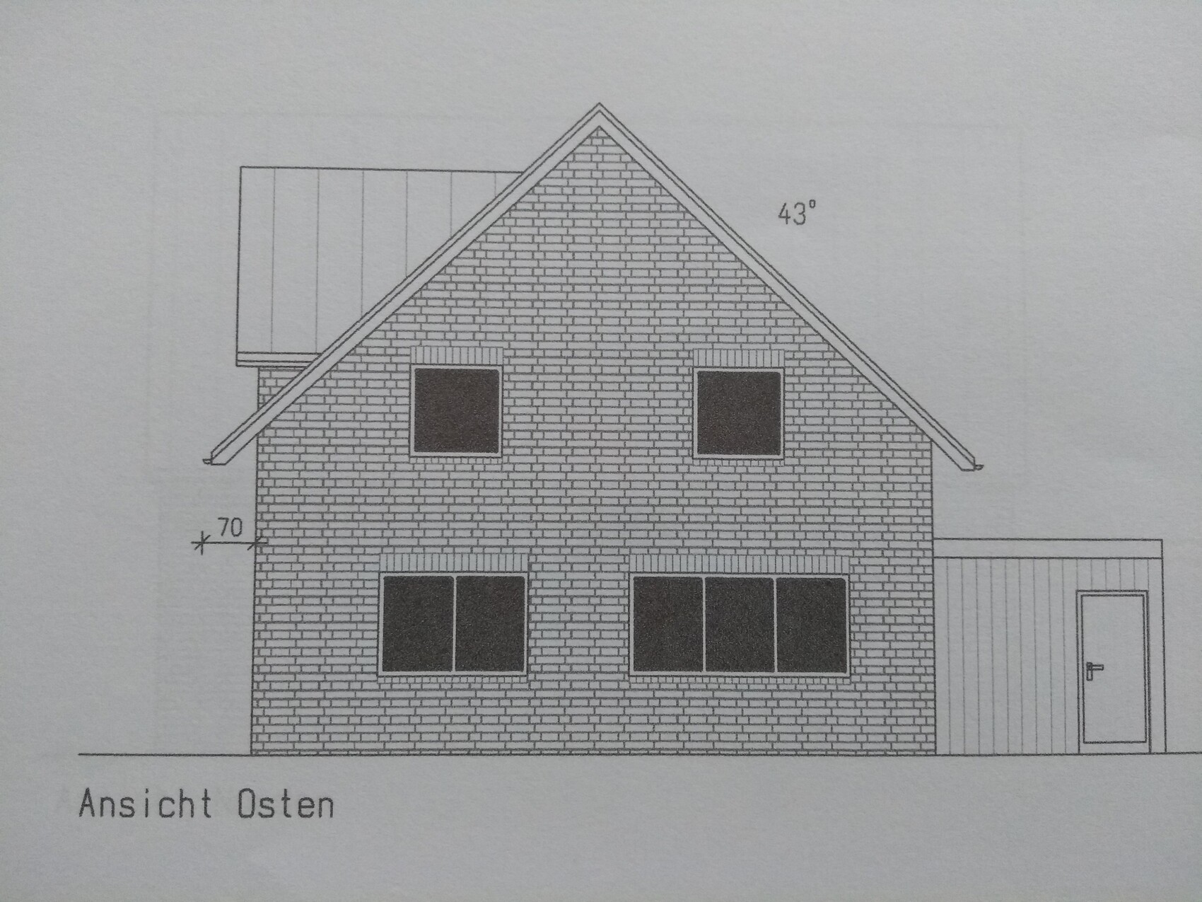 East elevation of a two-story brick house with gable roof and attached extension with door on the right.