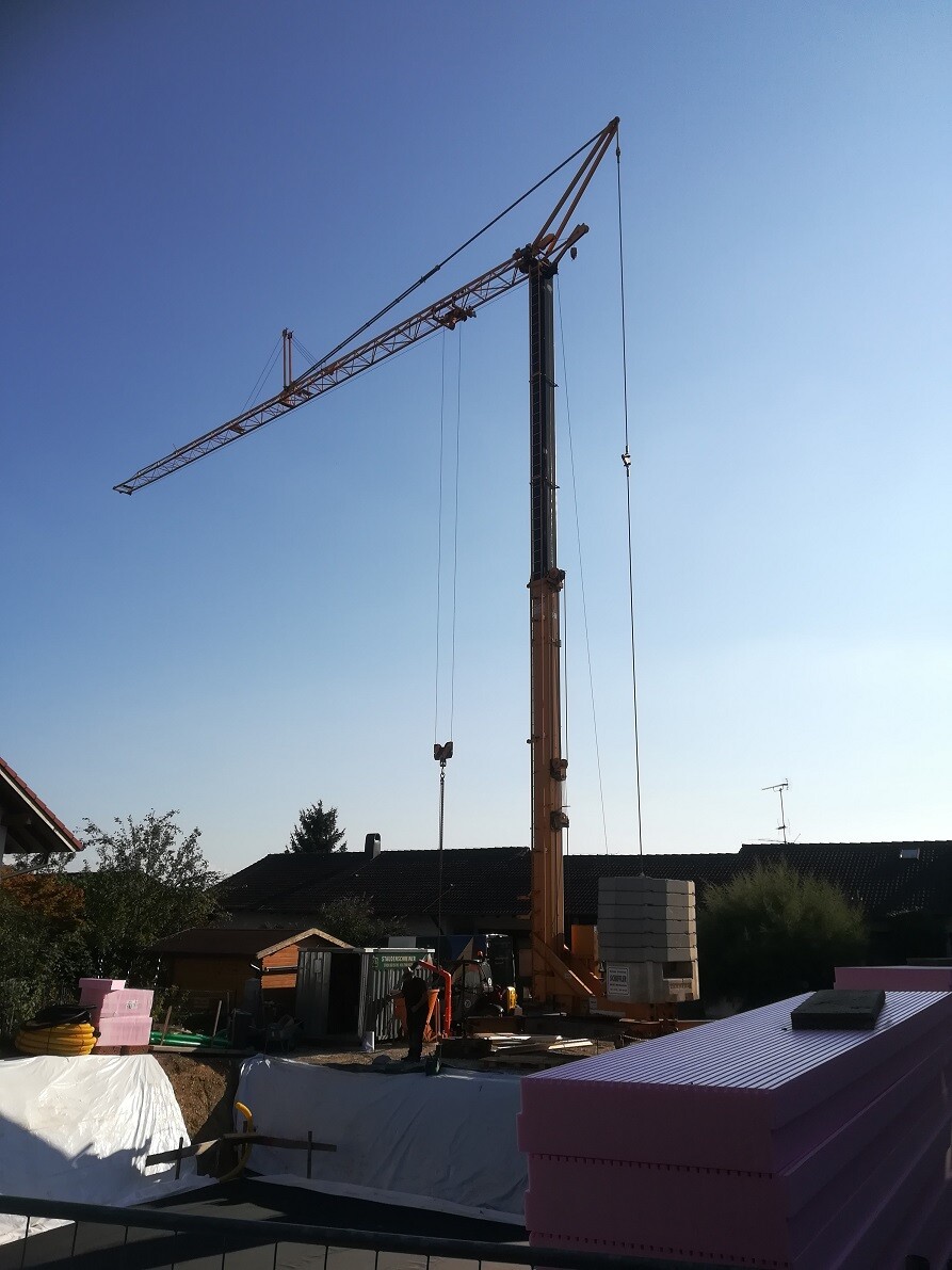 Large construction site with crane, foundation work and building materials