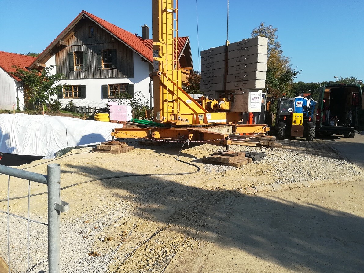 Construction site with crane, drilling rig and shell of a house
