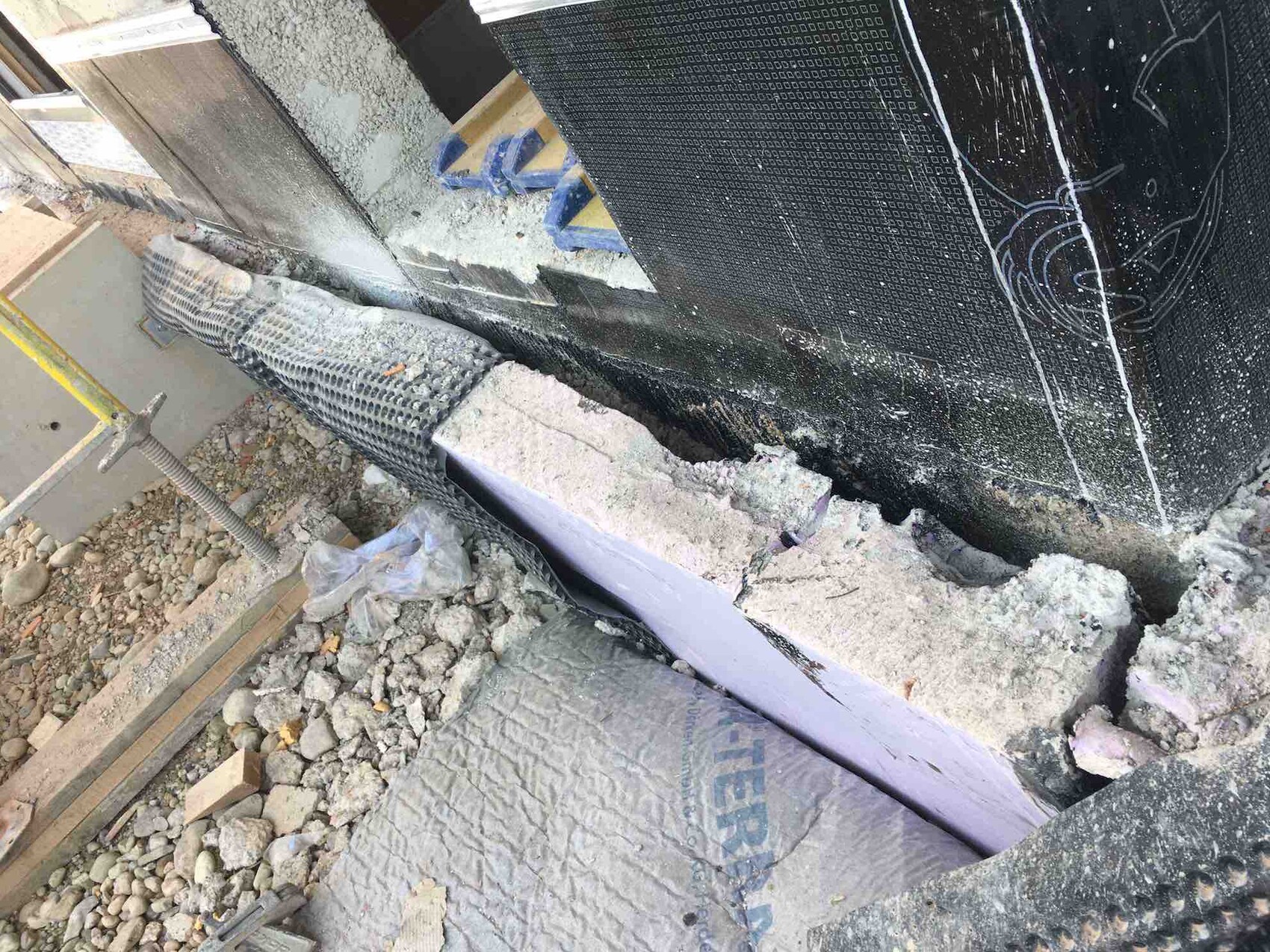 Construction site with foundation shell, waterproofing, and insulation on the wall