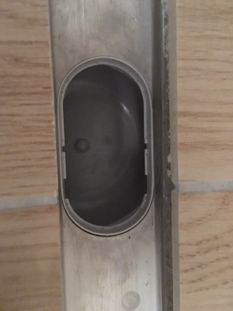 Metal channel with oval opening in wooden floor during construction work