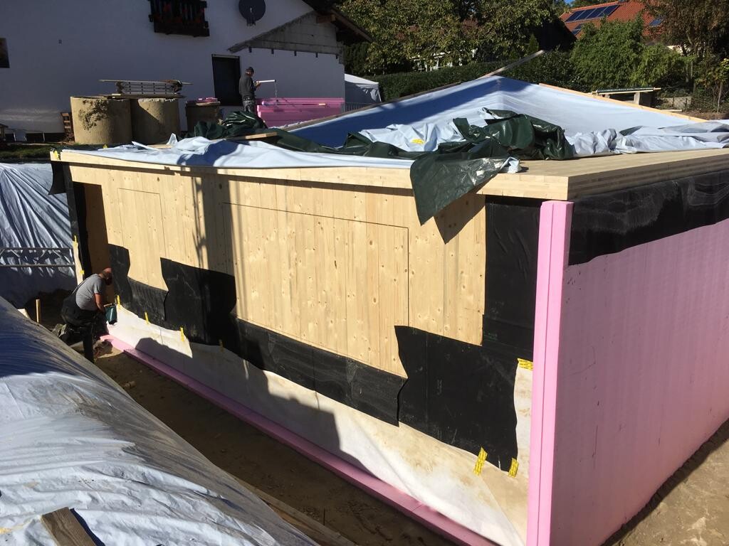 Construction site: wooden panel wall with insulation and waterproof membrane on shell construction