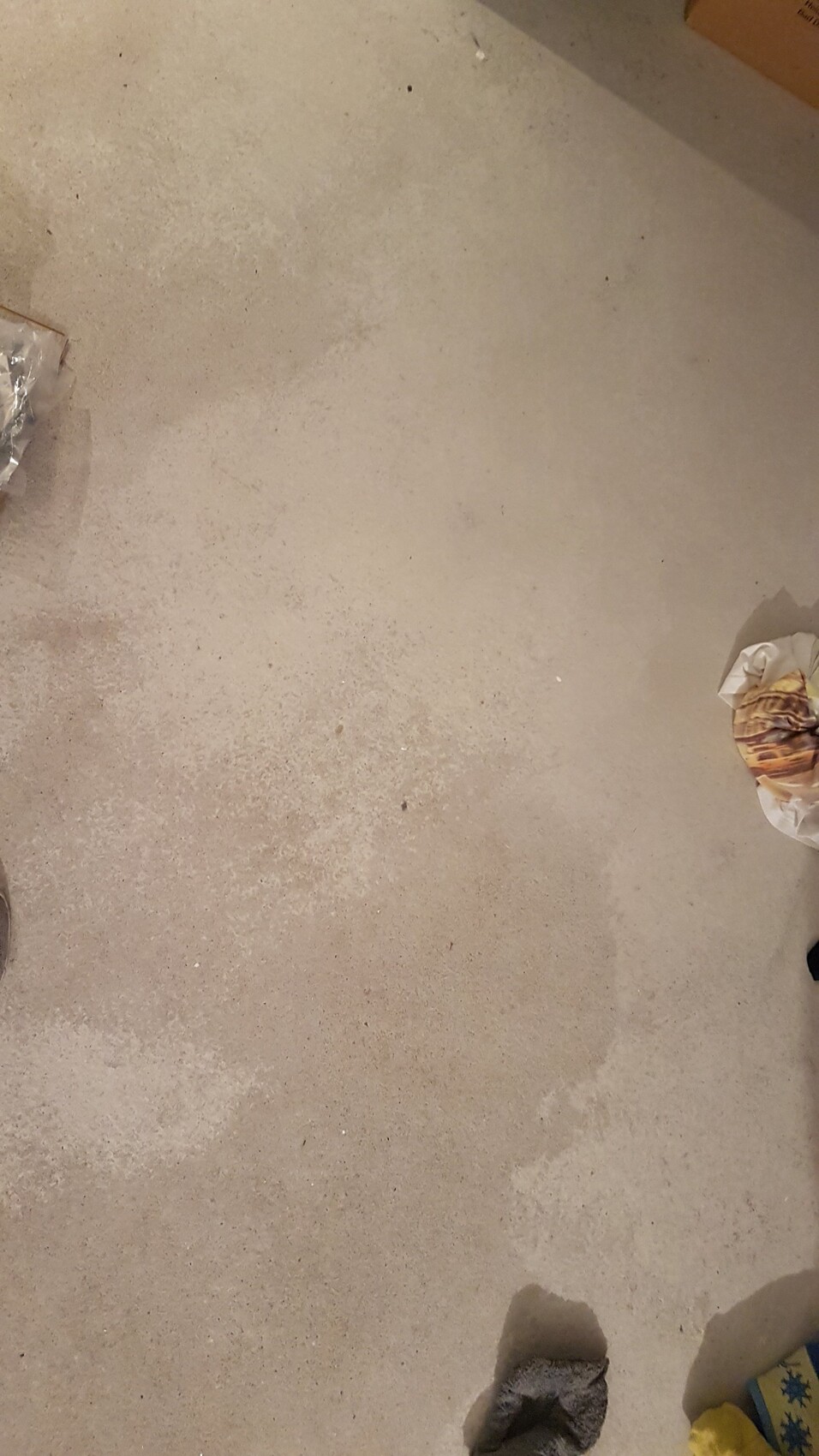 Unbearbeiteter Betonboden im Rohbau mit Bauabfällen.