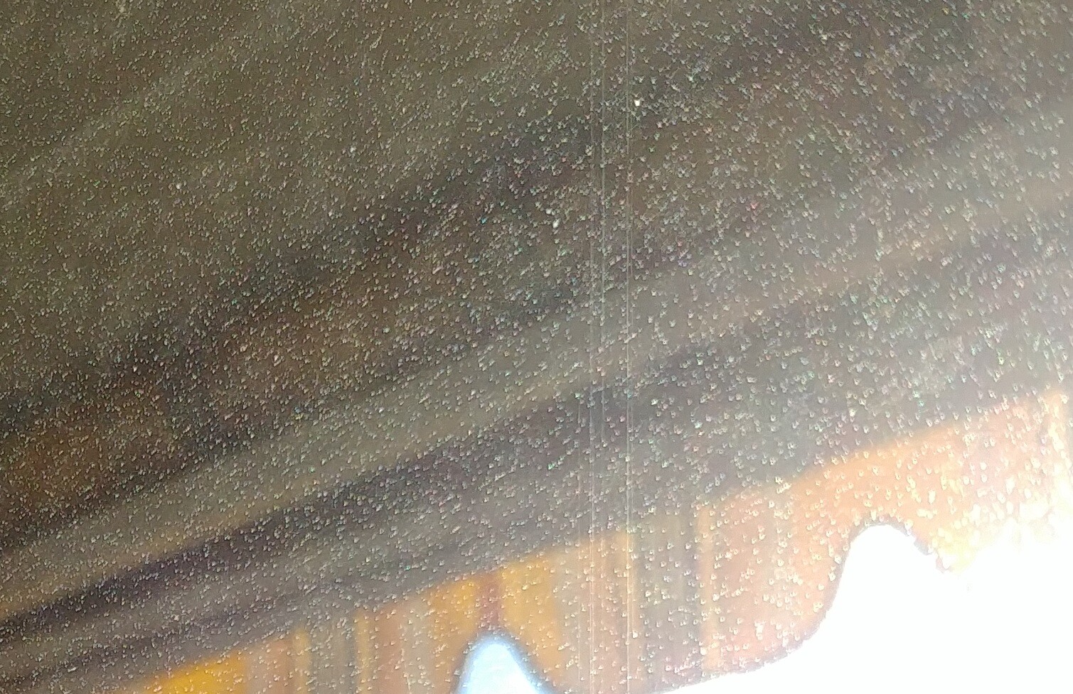 Close-up of a window pane with many water droplets and wooden frame
