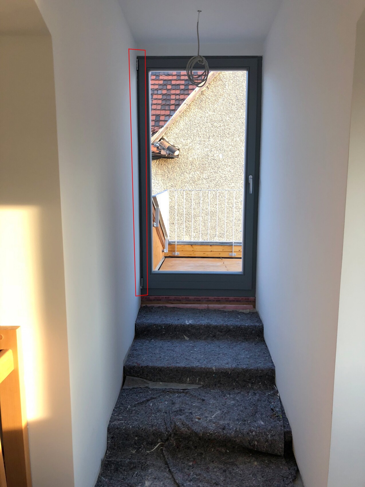 Small bright hallway with stairs leading to the exterior door and a balcony view
