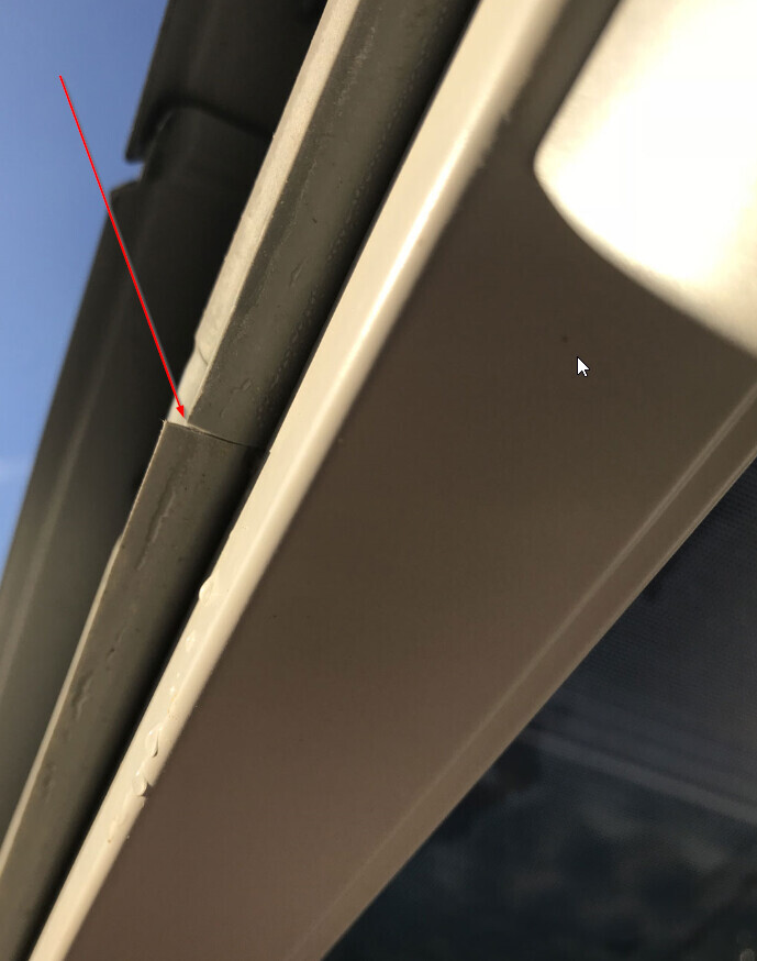 Close-up of a window frame with a visible gap and damage to the sealing joint
