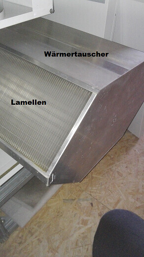 Metal heat exchanger with visible fins inside a casing.