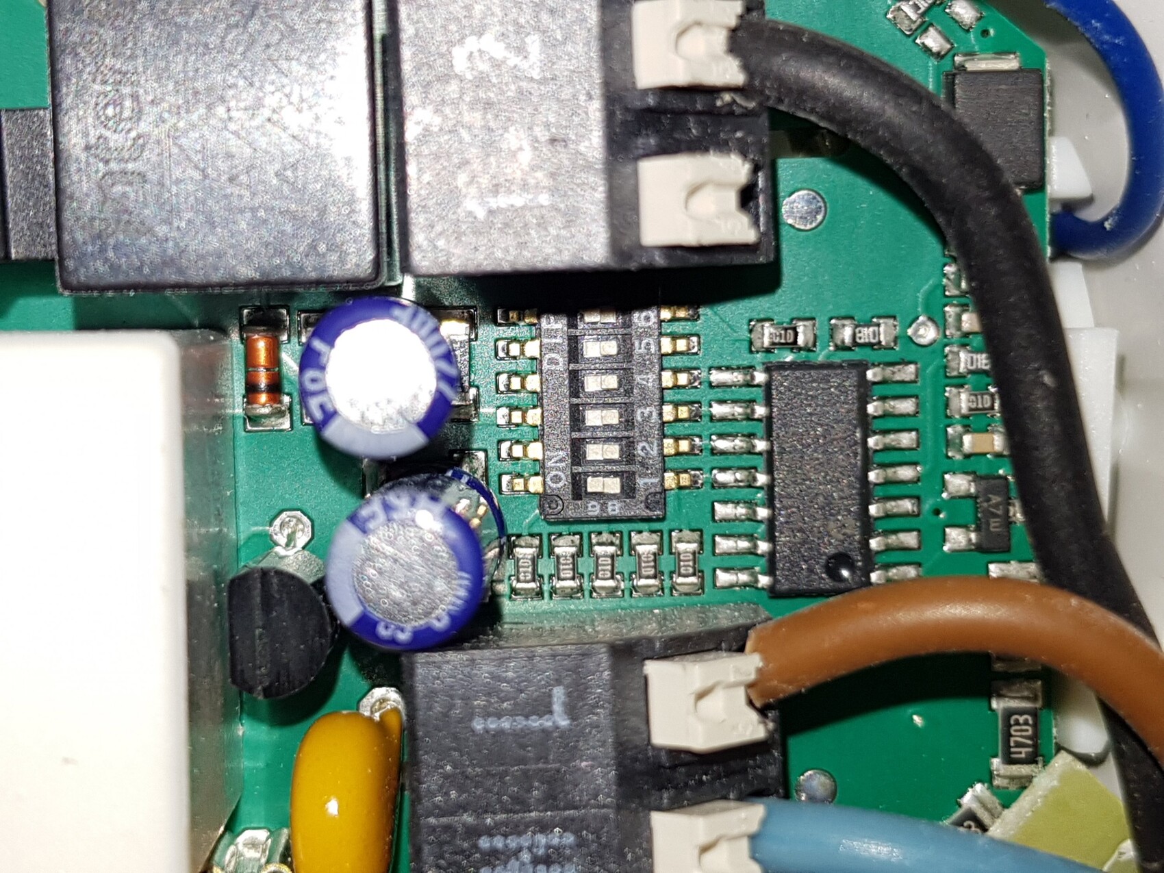 Close-up of a PCB board with capacitors, ICs, and cable connections