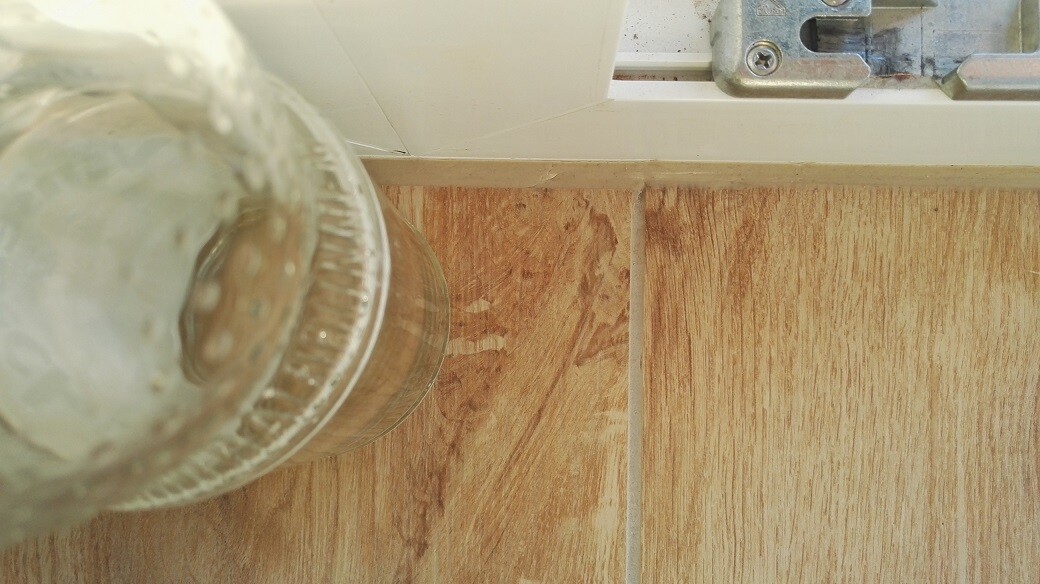 Close-up of a wood or laminate floor with joints next to the door frame
