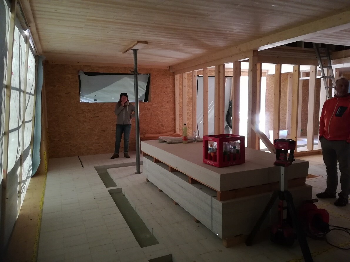 Interior construction site with wooden frame structure, ongoing work, and workspace
