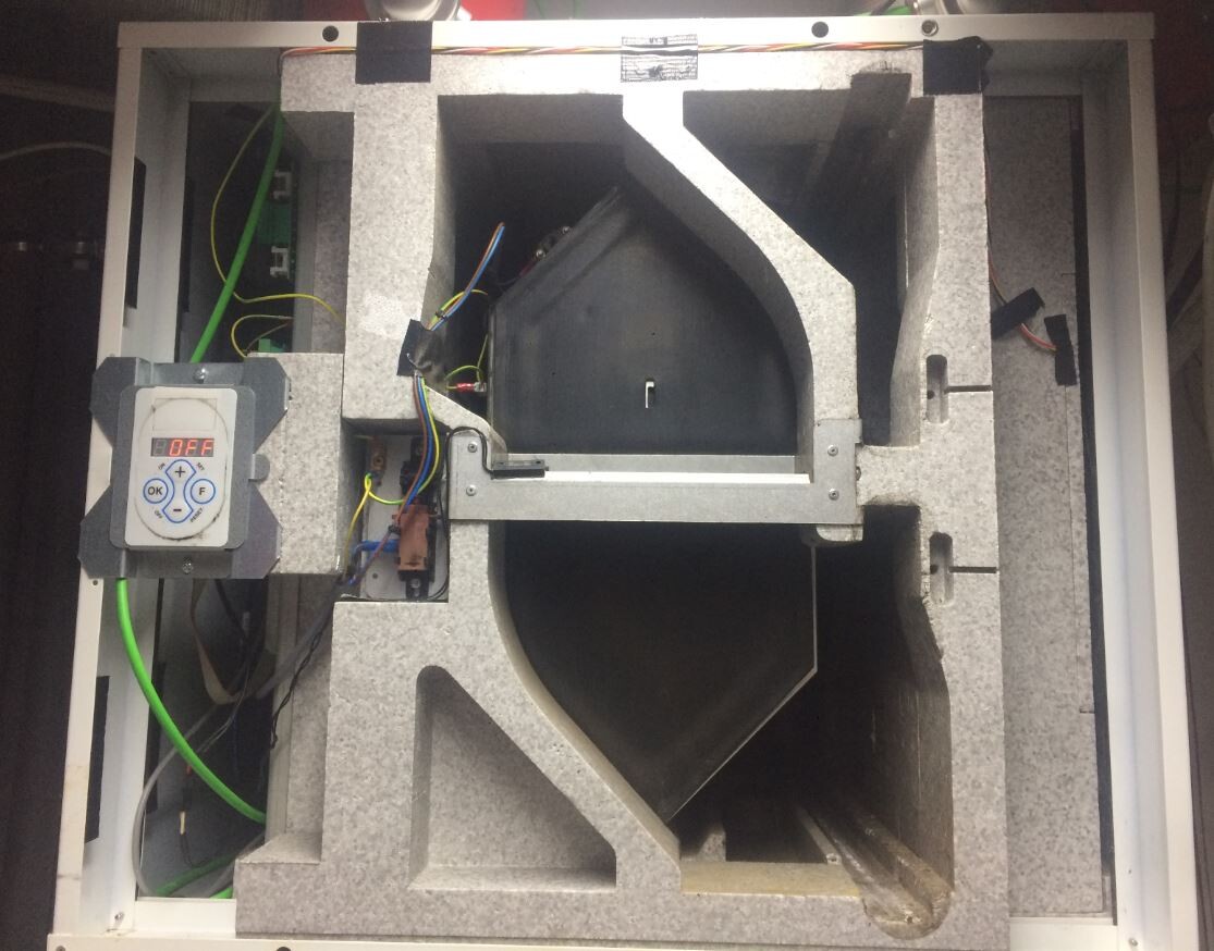 Interior view of a ventilation or fan box with control unit, cables, and insulation.