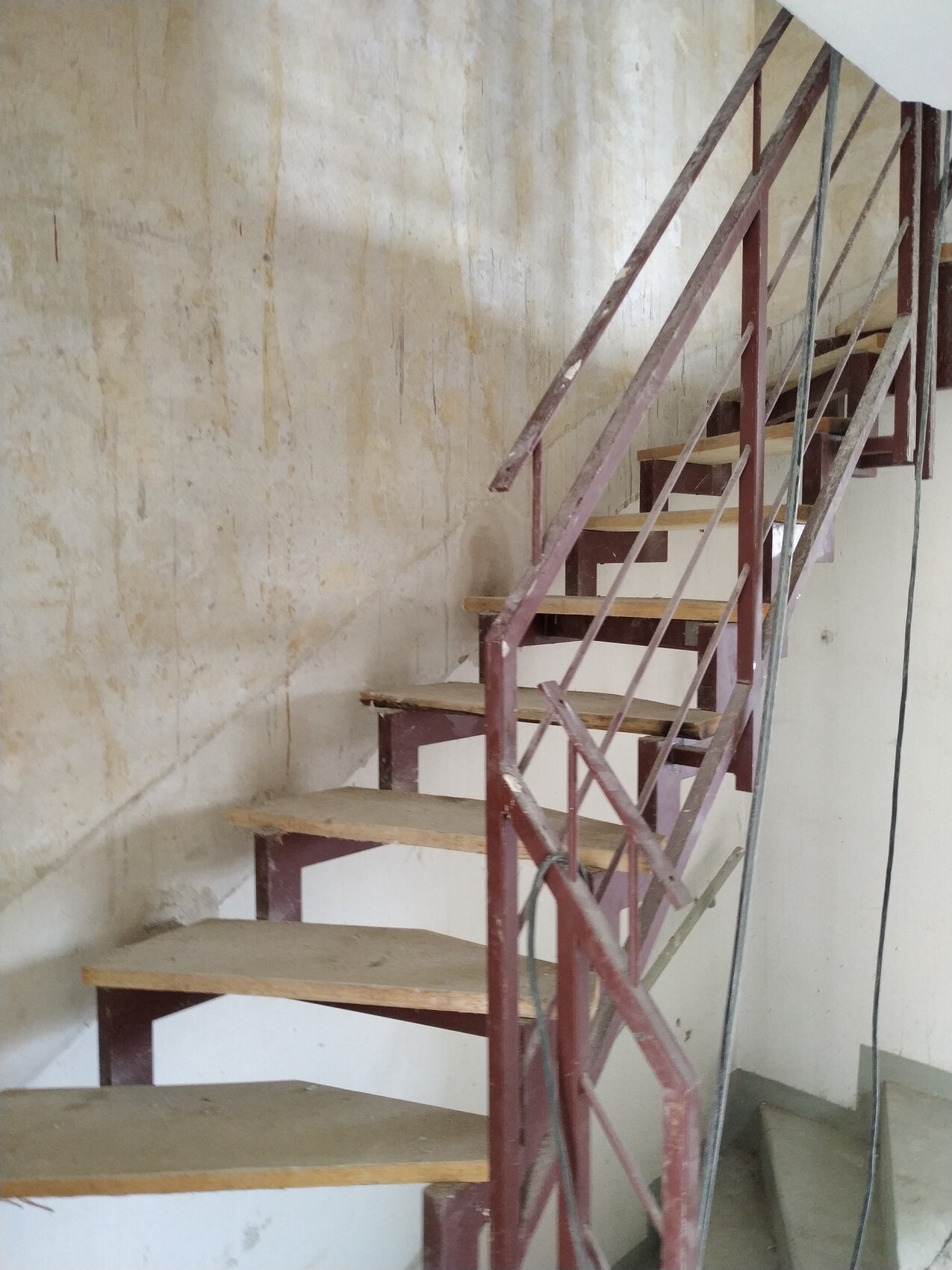 Steel staircase during construction phase next to raw concrete wall