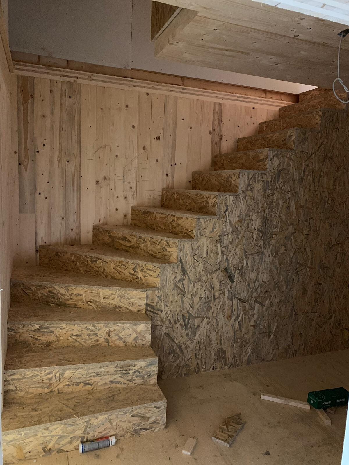 Unfinished wooden staircase made of OSB boards in the structural interior
