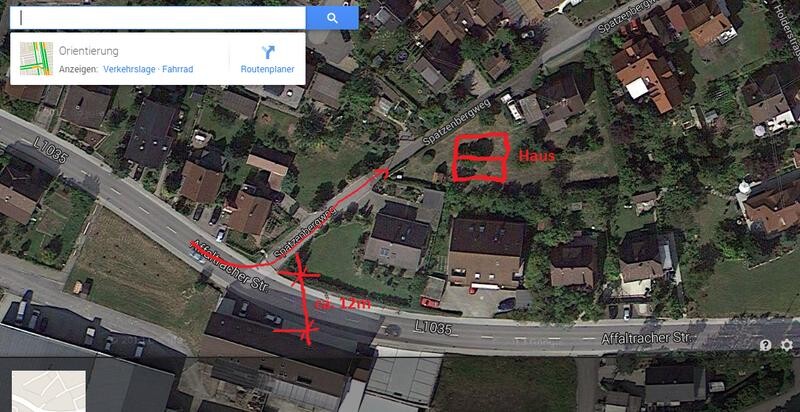 Satellite view of a residential area with marked house plot.