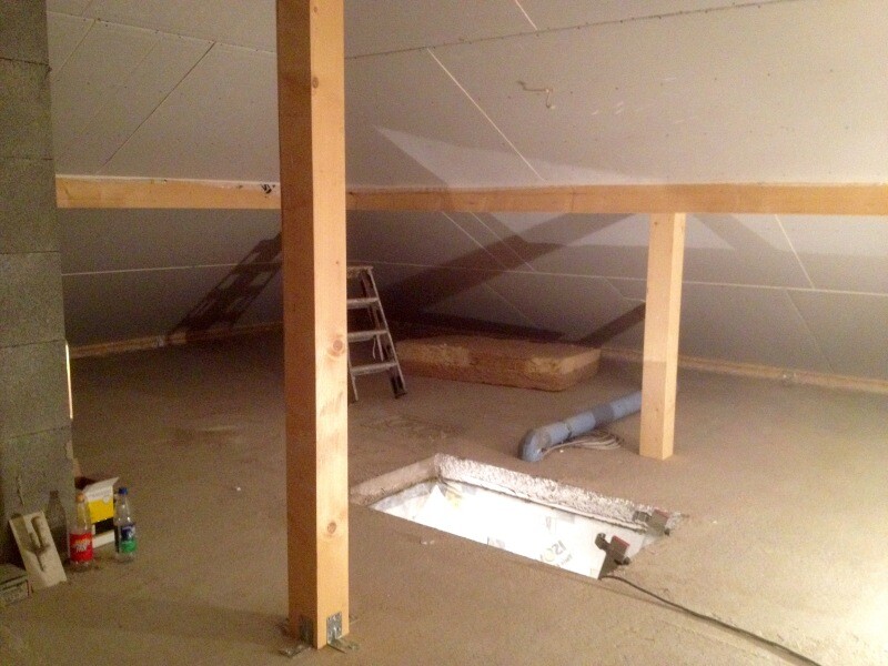 Unfinished attic under construction with wooden beams, ladder, and open floor hatch