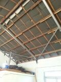 Interior view of a shell building with wooden roof structure and metal construction in the roof area