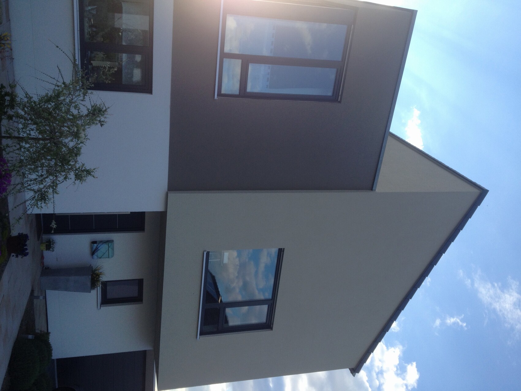 Modern white house facade with large windows and entrance area