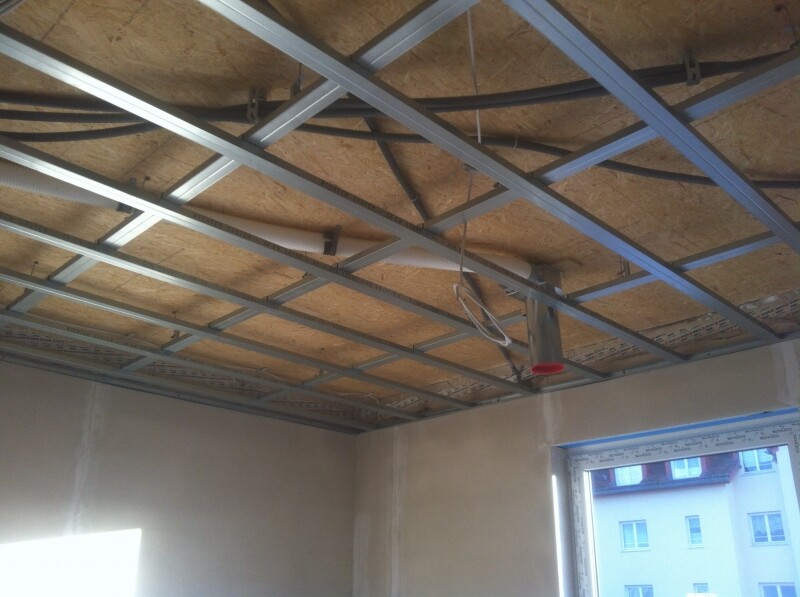 Gebäudedecke im Rohbau: Metallraster, Kabel, OSB-Platten, Fensteransicht