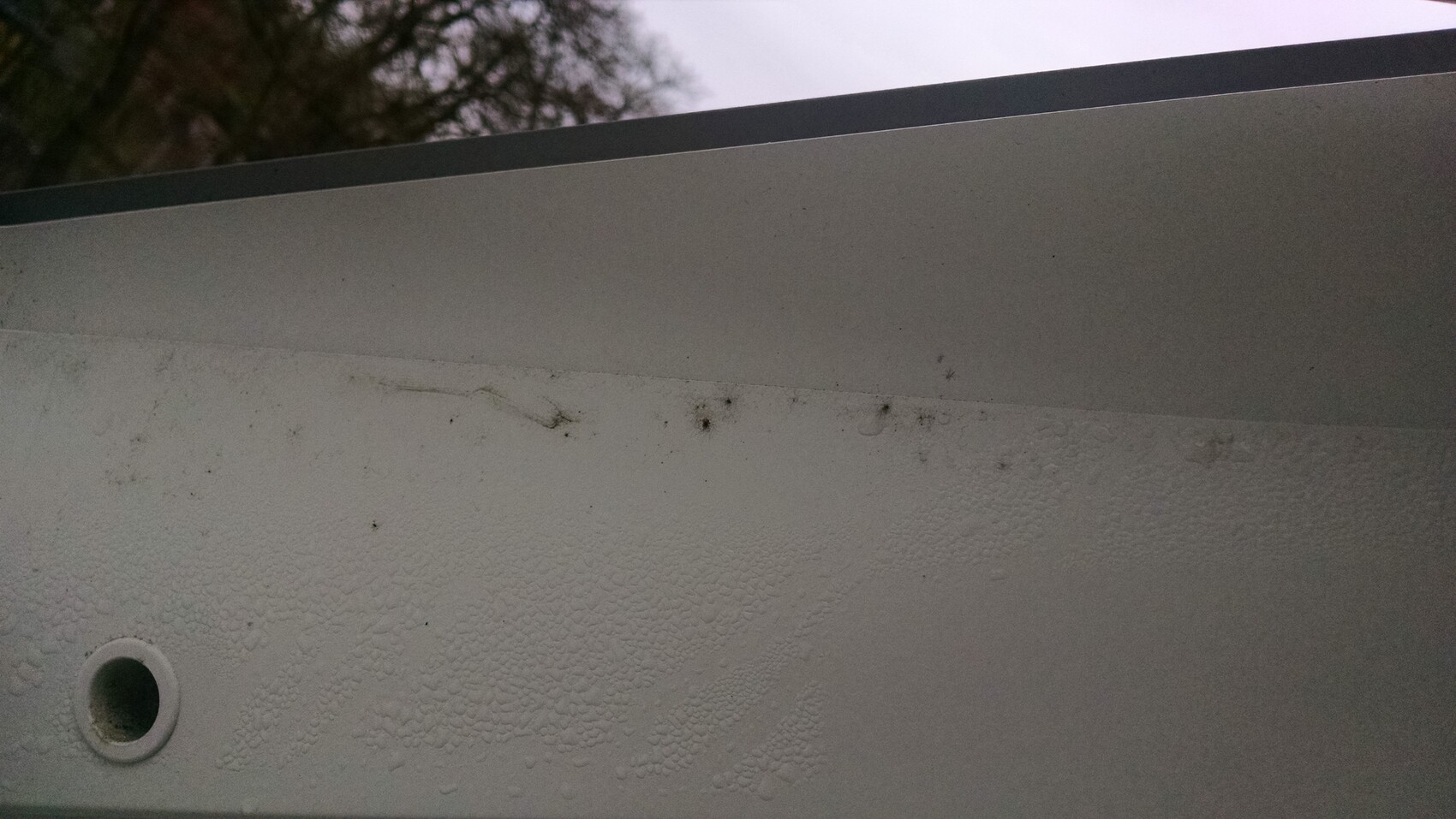 Close-up of a bathtub surface with drainage and rough texture