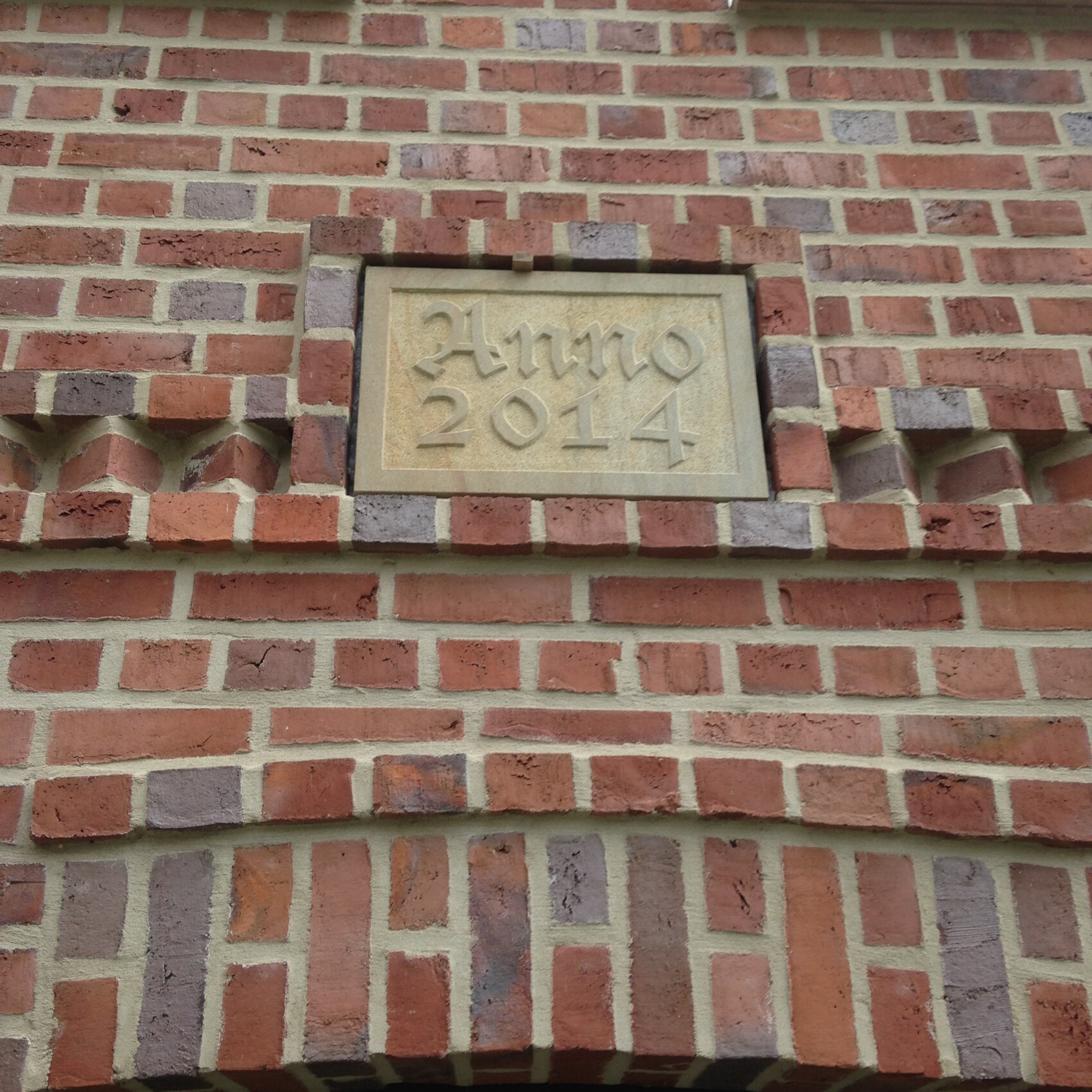 Brick facade with stone plaque dated 2014 on the wall