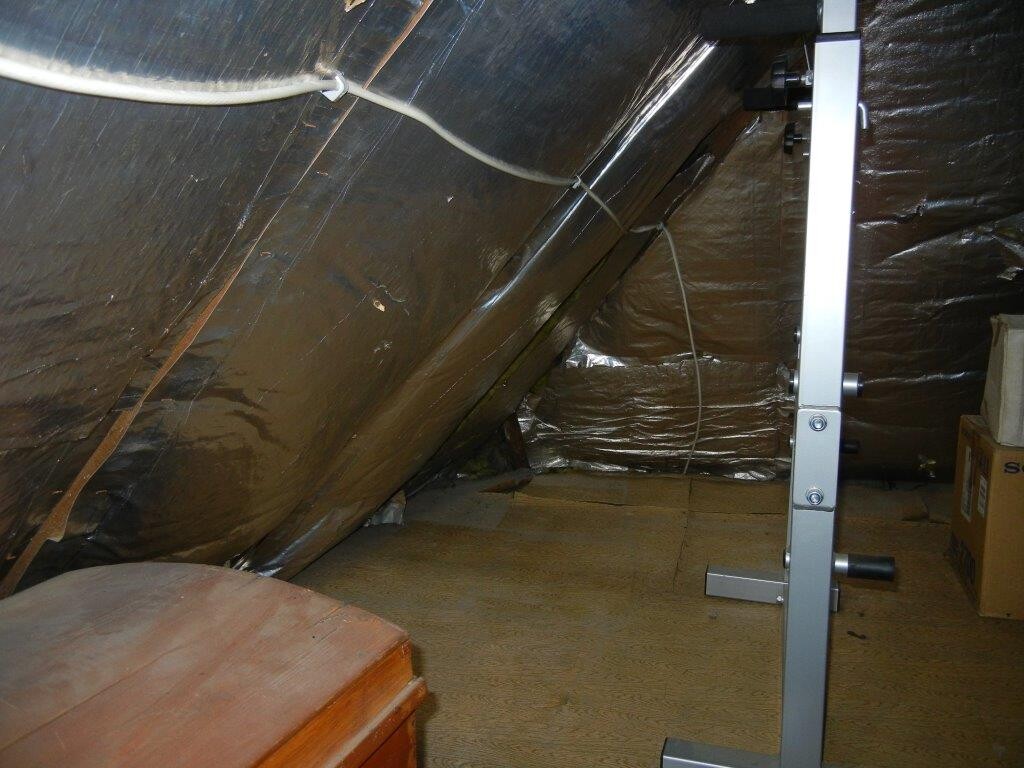 Dachboden mit Folien-Daemmung, Kabeln und Metallständer während Bauarbeiten