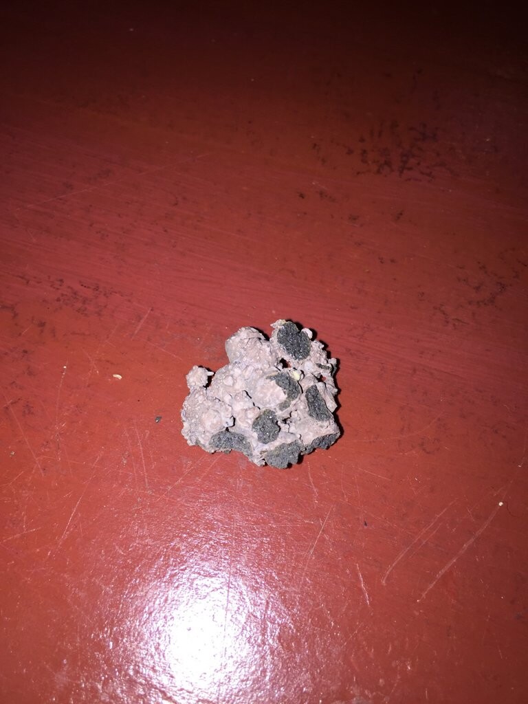 Small concrete lump on red floor, construction debris from shell construction
