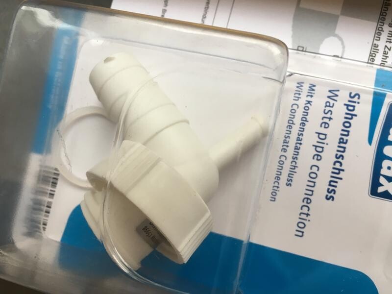 White plastic siphon connection in original packaging, plumbing part