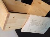 Wood frame construction next to floor plan on the table.